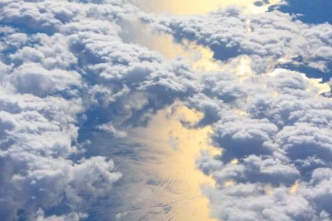 Clouds are dense and fluffy with sunlight reflecting Stock Photos