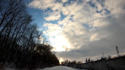 Clouds are floating above the trees. Winter road. Video stock 126791971