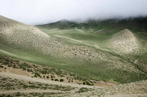 Clouds are moving down to the nepalese high mountain green valley Stock Photos