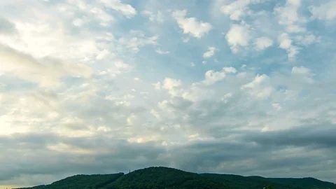 The clouds are moving in opposite directions over the mountain. Timelapse. Stock Footage 77654438