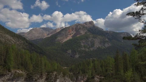 Clouds are moving over mountains covered with forest in the light of day 스톡 동영상 77660736