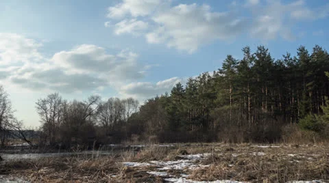 Clouds are moving over the trees and river. Time-lapse Stock-Footage 24630833