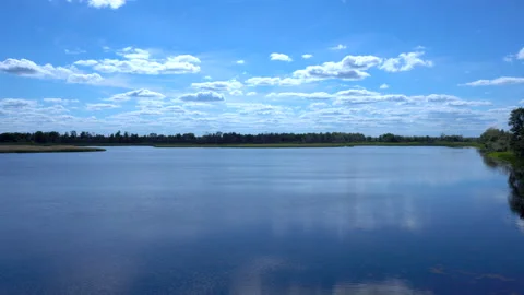 Clouds are reflected in the lake. View of the lake in the distant grass and 库存影片 123665397
