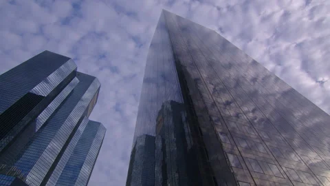 Clouds are reflected in a mirrored glass skyscraper in a business district Stock Footage 221023903