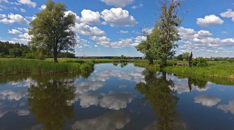 Clouds are reflected in the river, blue sky in the lake Stock Photos
