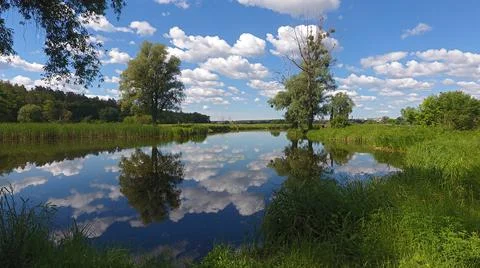 Clouds are reflected in the river, blue sky in the lake Stock Photos