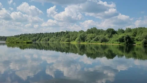 Clouds are reflected in the river. Forest on the river bank. Beautiful landscape Stock Footage 245275323