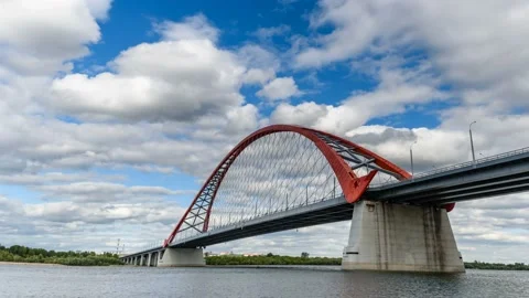 Clouds are running in the blue sky over the red bridge over the Ob river. Stock Footage 93612894