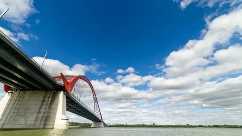 Clouds are running in the blue sky over the red bridge over the Ob river. Stock Footage 93627483