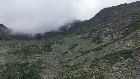 Clouds are slowly moving over a rocky mountain valley Stock Footage 300929471