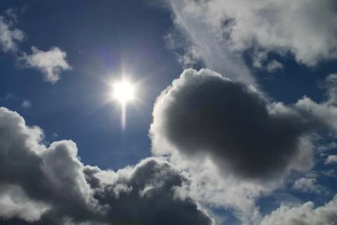 Clouds on a background of blue sky and sun Stock Photos