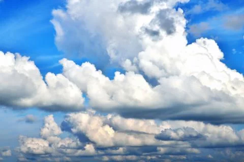 Clouds on the background of bright blue sky, summer day close-up Stock Photos