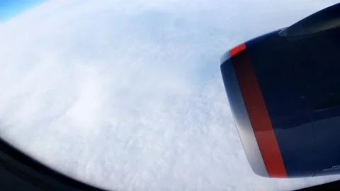 Clouds behind the porthole, blue sky and turbine are visible through the plane's Stock Footage 166209032
