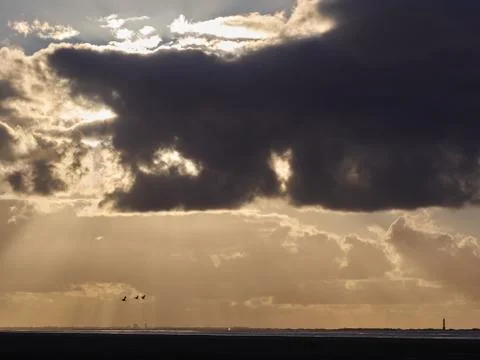Clouds, birds and a lighthouse Stock Photos
