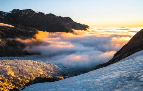 Clouds blanket the Fox Glacier during sunset in New Zealand Stock Photos