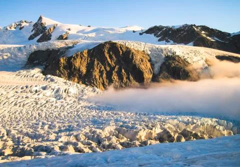 Clouds blanket the Fox Glacier during sunset in New Zealand Stock Photos