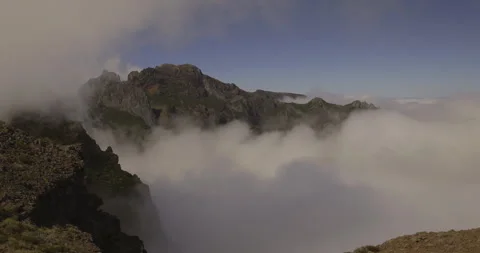 Clouds blowing onto mountain peaks, 4K fast motion Stock Footage 246380668