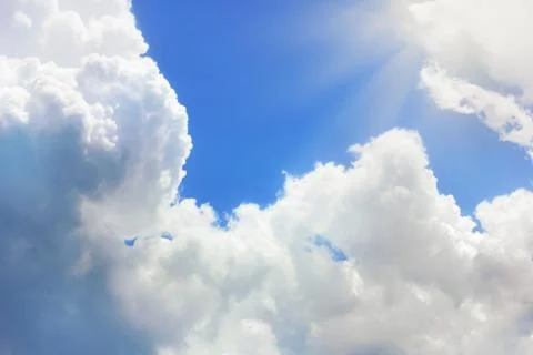 Clouds in blue sky and sun rays Stock Photos