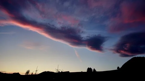 Clouds in the blue sky colored in pastel colors at dusk, silhouette of the Video stock 254547149