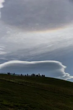 Clouds in the blue sky over the mountains with a group of people Stock Photos