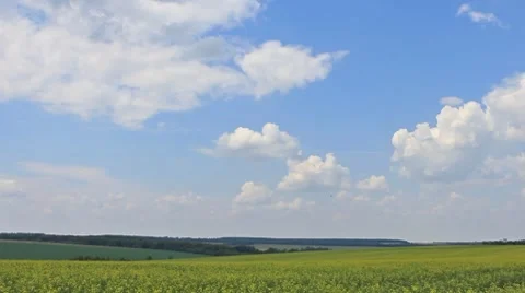 Clouds on blue sky over yellow field background panning Stock Footage 8312221