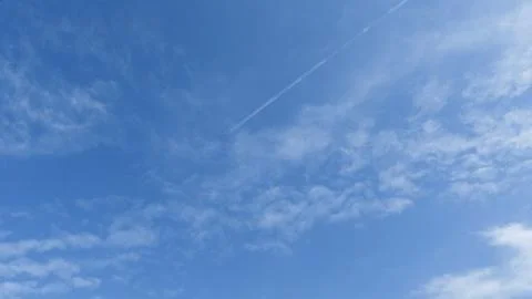 Clouds on blue sky with plane and contrails Stock Photos