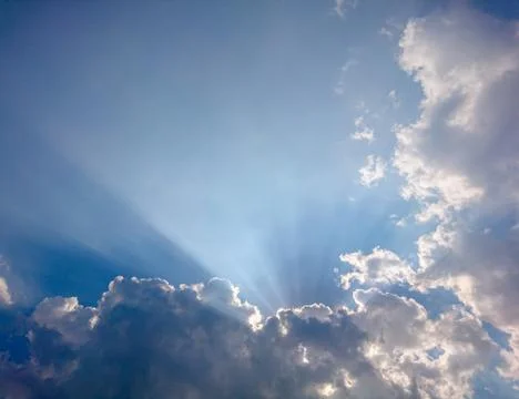 Clouds in blue sky with rays of light Stock Photos