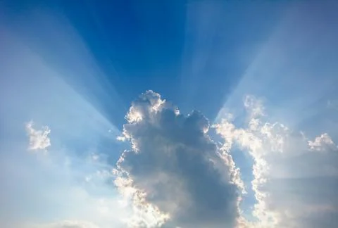 Clouds in blue sky with rays of light Stock Photos