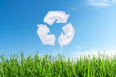 Clouds on the blue sky in shape of the symbol of recycling on green background Stock Photos