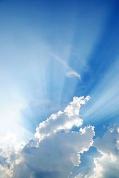 Clouds in blue sky with sunrays Stock Photos