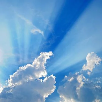 Clouds in blue sky with sunrays Stock Photos
