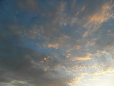 Clouds in the blue sky at sunset as an abstract background. Stock Photos