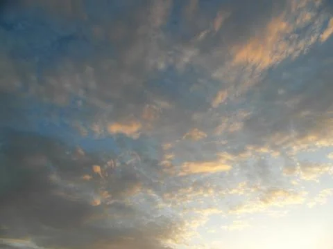 Clouds in the blue sky at sunset as an abstract background. Stock Photos