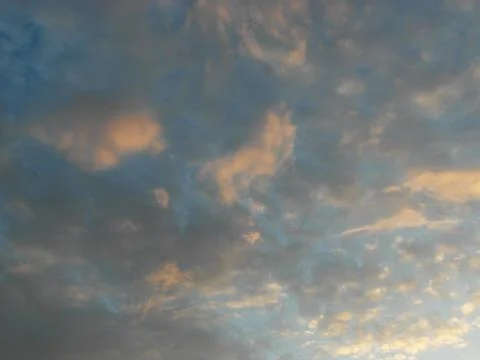 Clouds in the blue sky at sunset as an abstract background. Stock Photos