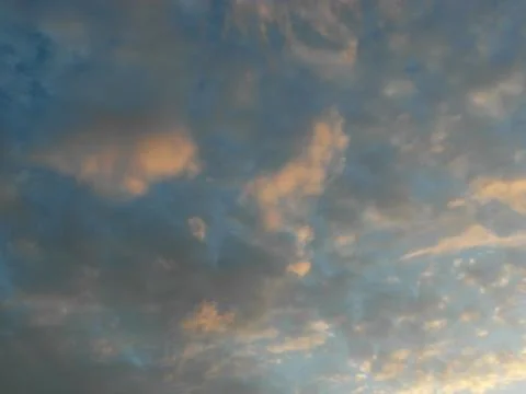 Clouds in the blue sky at sunset as an abstract background. Stock Photos