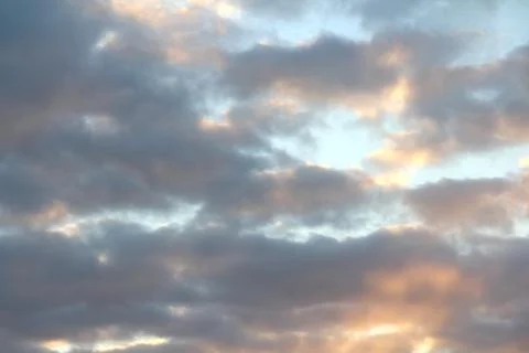 Clouds in the blue sky at sunset or dawn backlit by the sun. Place for text and Foto stock