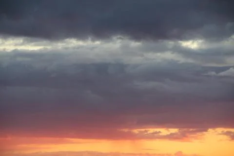 Clouds in the blue sky at sunset or dawn backlit by the sun. Place for text and Stock Photos