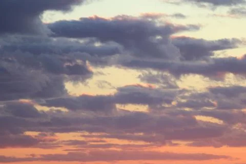 Clouds in the blue sky at sunset or dawn backlit by the sun. Place for text and Stock Photos