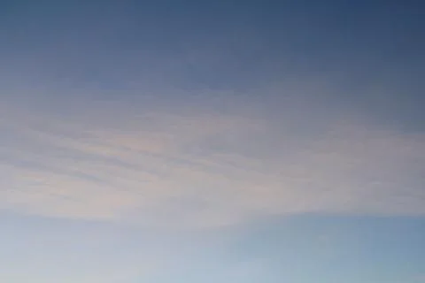 Clouds in the blue sky at sunset or dawn backlit by the sun. Place for text and Stock Photos