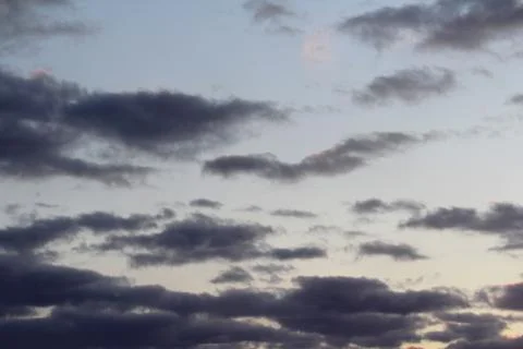 Clouds in the blue sky at sunset or dawn backlit by the sun. Place for text and Stock Photos