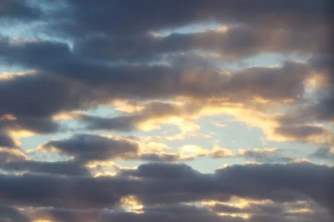 Clouds in the blue sky at sunset or dawn backlit by the sun. Place for text and Foto stock