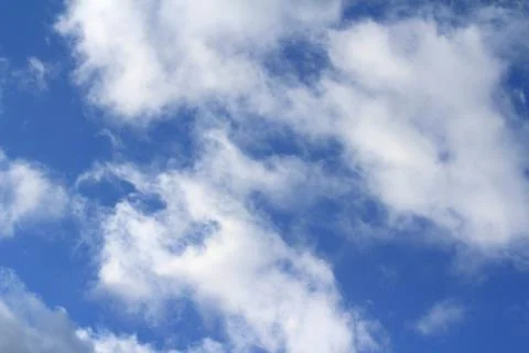 Clouds in the blue sky at sunset or dawn backlit by the sun. Place for text and Stock Photos