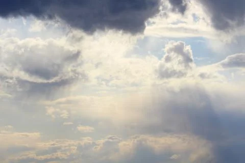 Clouds in the blue sky at sunset or dawn backlit by the sun. Place for text and Stock Photos
