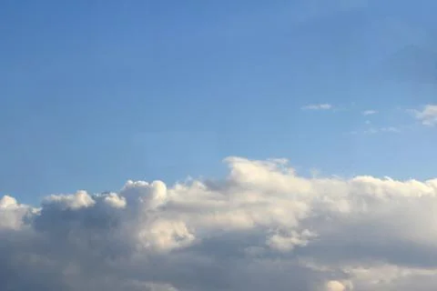 Clouds in the blue sky at sunset or dawn backlit by the sun. Place for text and Stock Photos