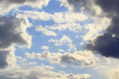 Clouds in the blue sky at sunset or dawn backlit by the sun. Place for text and Stock Photos