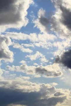 Clouds in the blue sky at sunset or dawn backlit by the sun. Place for text and Stock Photos