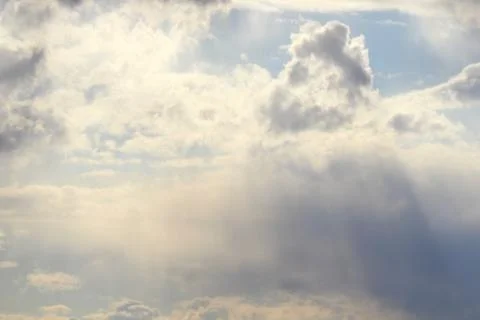Clouds in the blue sky at sunset or dawn backlit by the sun. Place for text and Stock Photos
