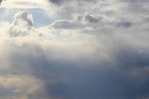 Clouds in the blue sky at sunset or dawn backlit by the sun. Place for text and Stock Photos