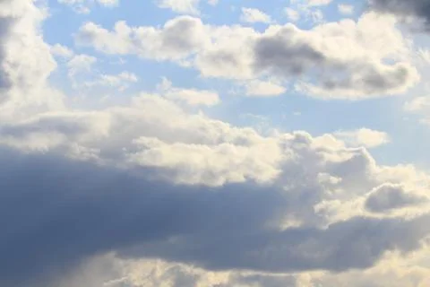 Clouds in the blue sky at sunset or dawn backlit by the sun. Place for text and Stock Photos