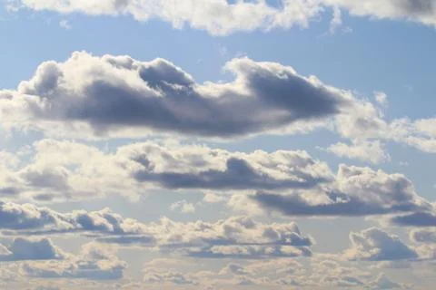 Clouds in the blue sky at sunset or dawn backlit by the sun. Place for text and Stock Photos